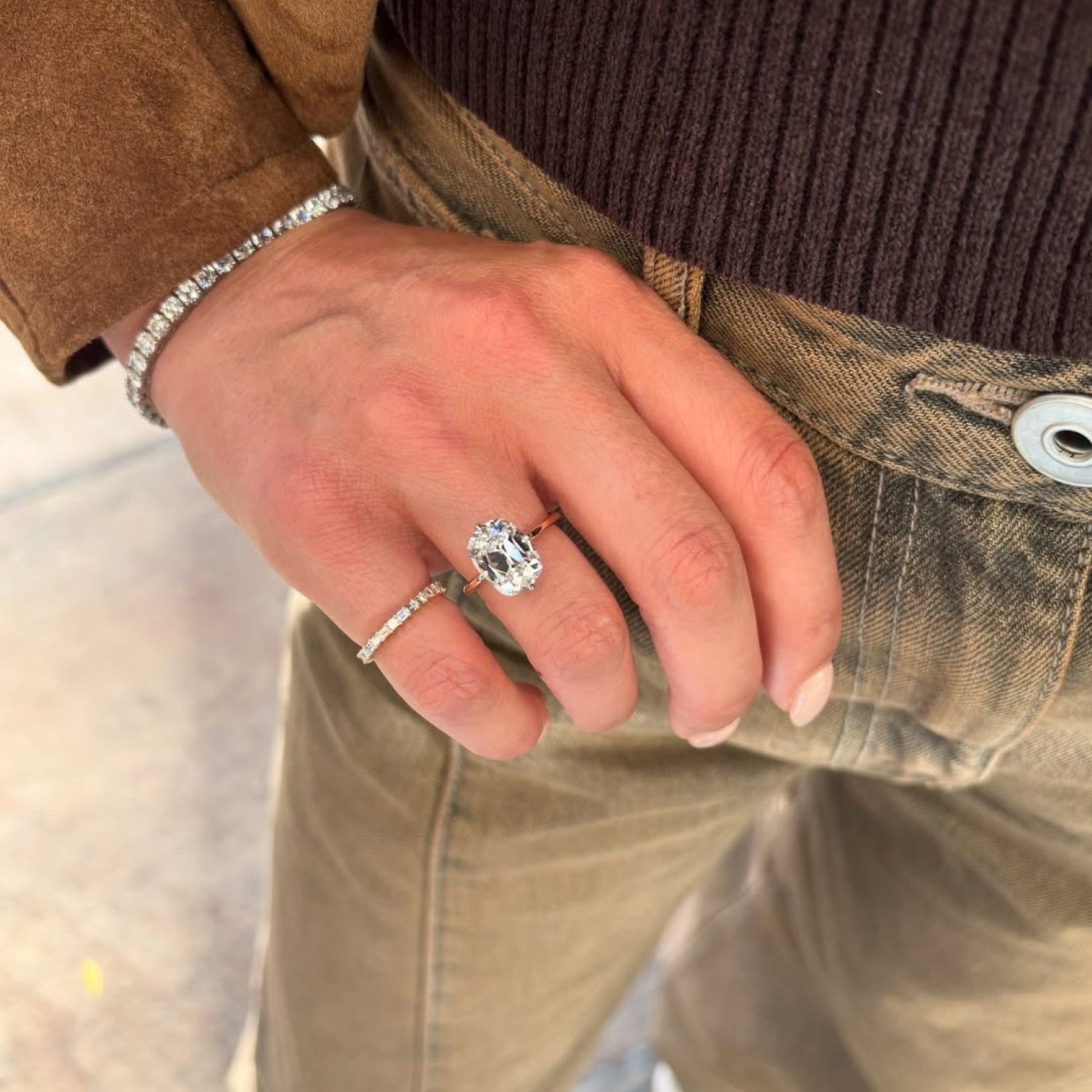 Close-up of a hand wearing a diamond ring with a blurred background