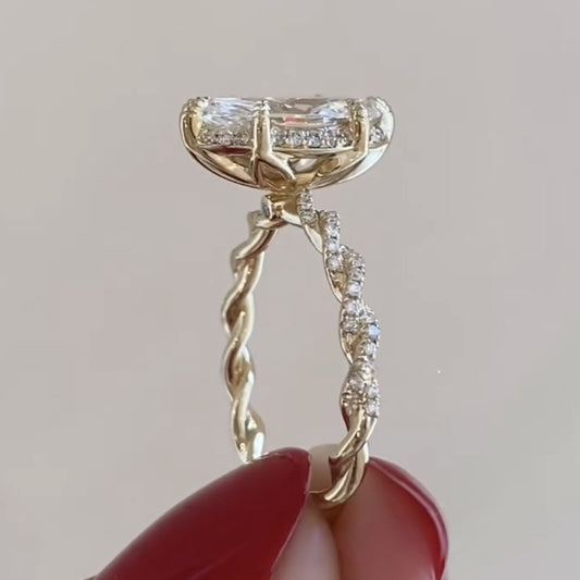 Gold ring with diamond accents held by a hand with red nail polish on a neutral 