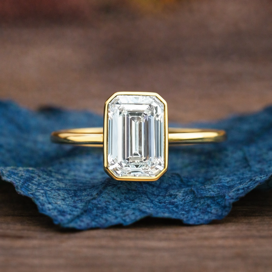 Gold ring with a large diamond on a textured blue fabric 