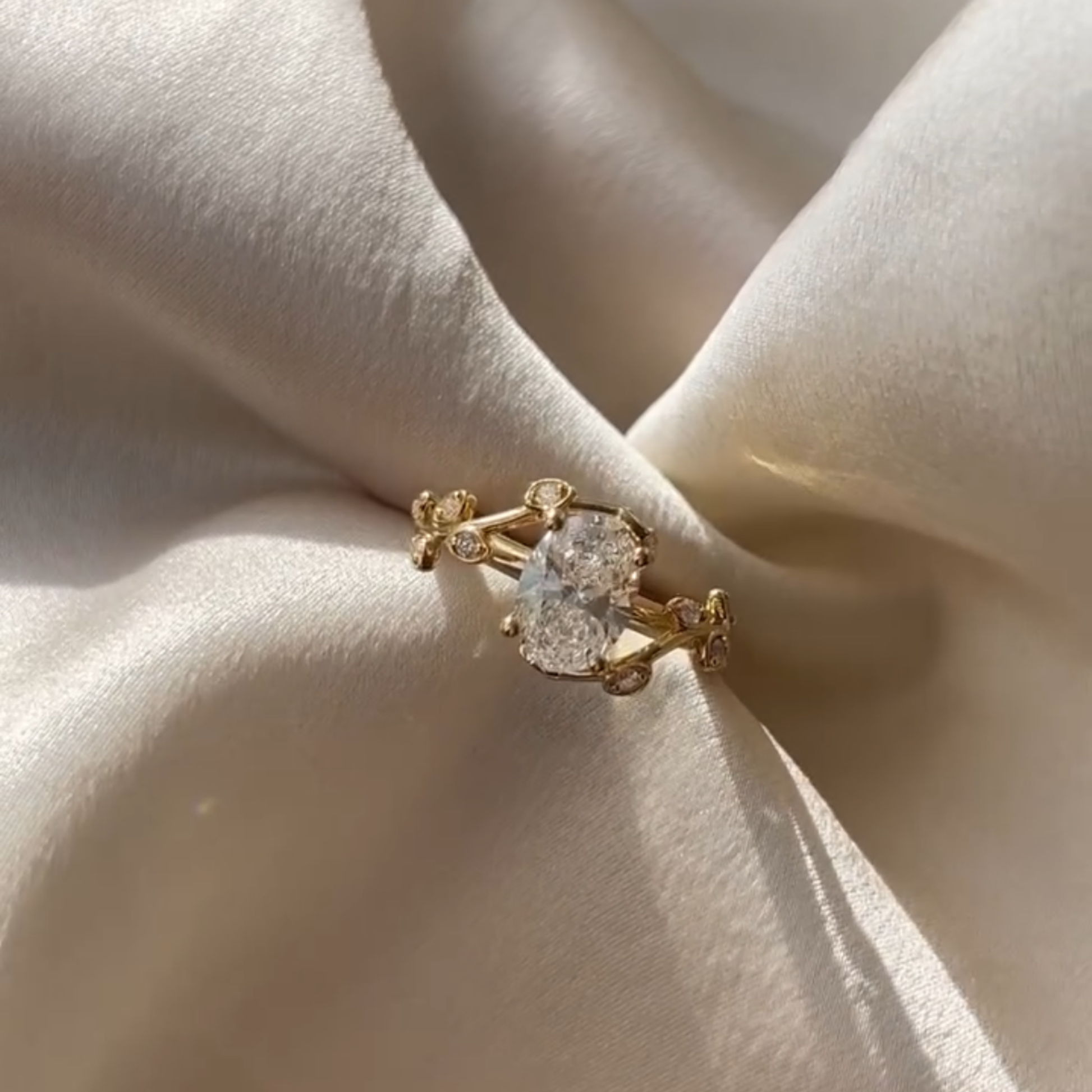 Gold ring with a large diamond on a beige fabric 