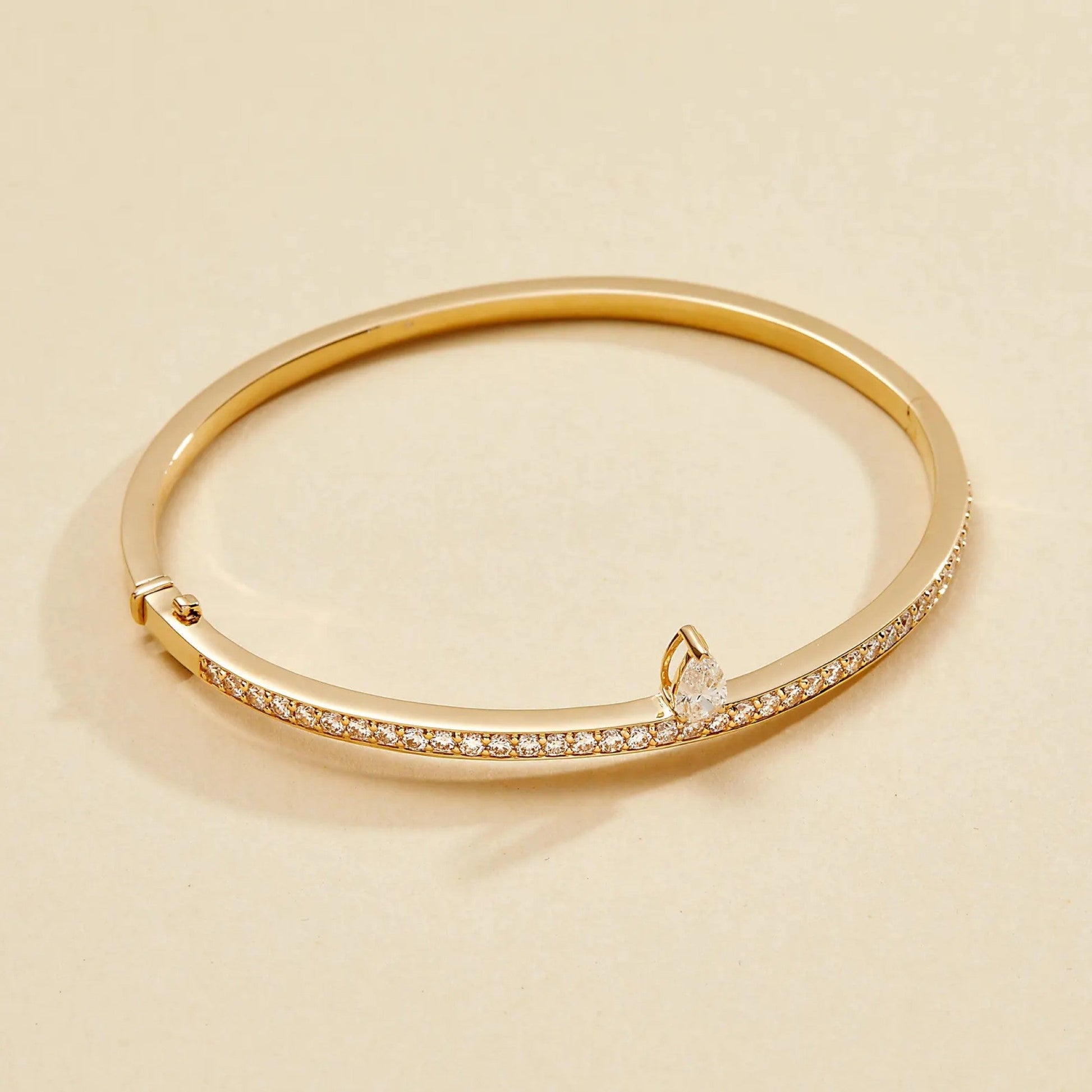 Gold bracelet with small diamonds on a beige 