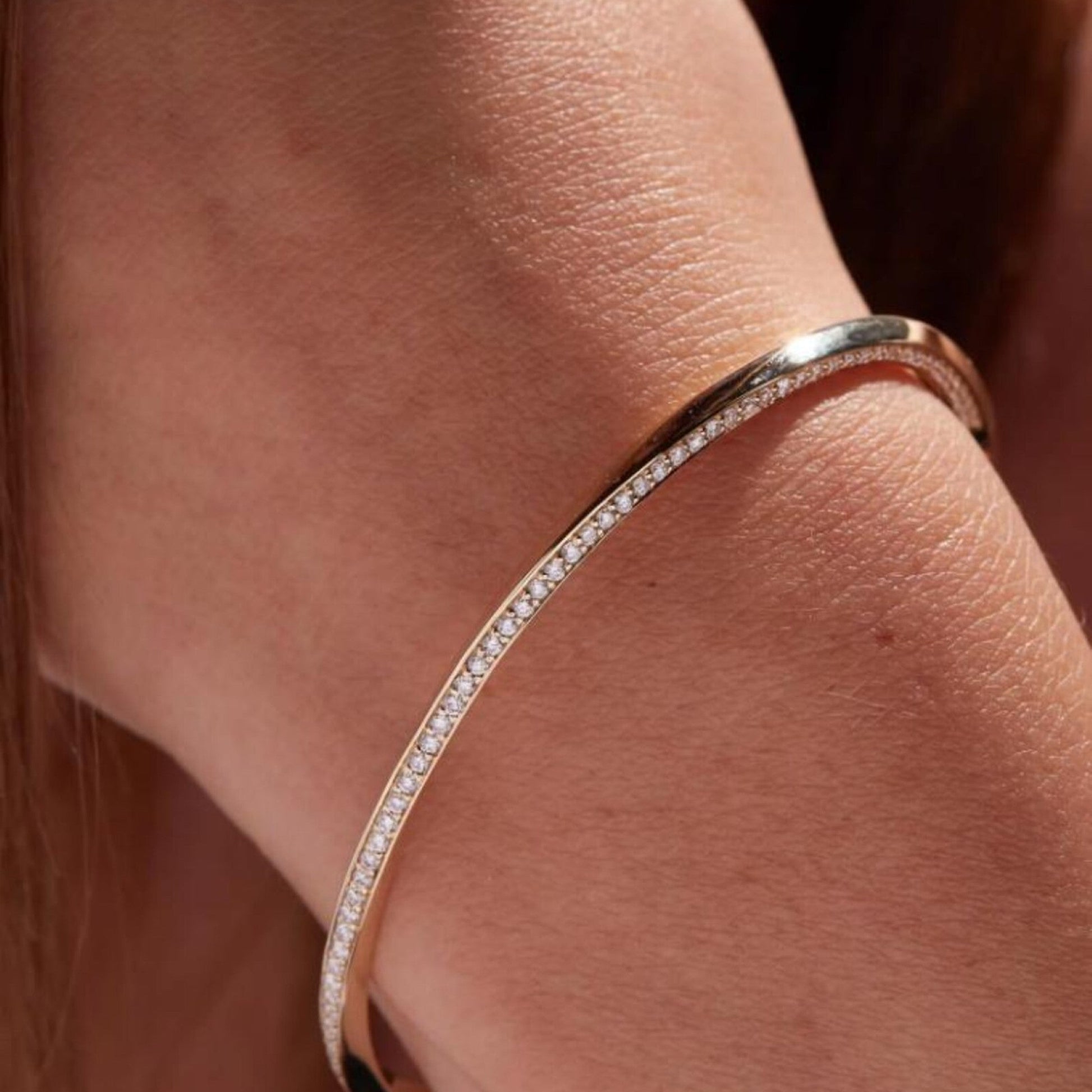 Rose gold bangle with diamonds on a wrist