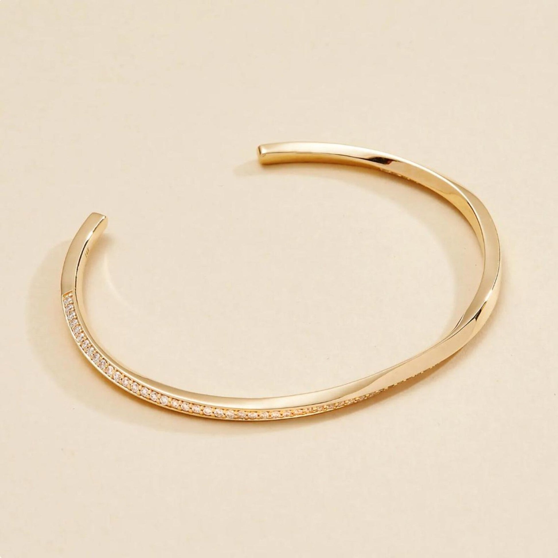 Gold bracelet on a beige 