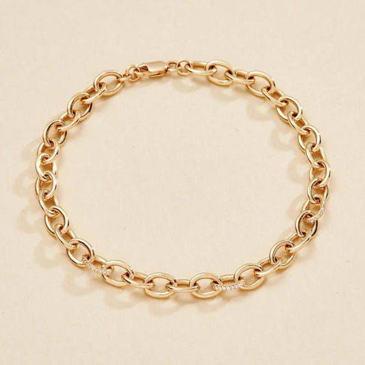 Gold chain bracelet on a beige 